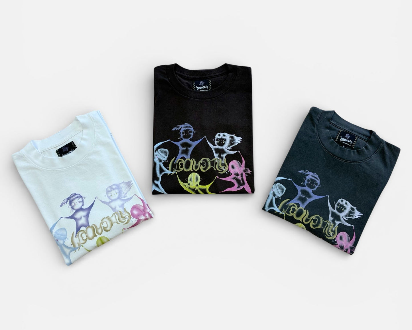 Three folded t-shirts with colorful designs on a white background